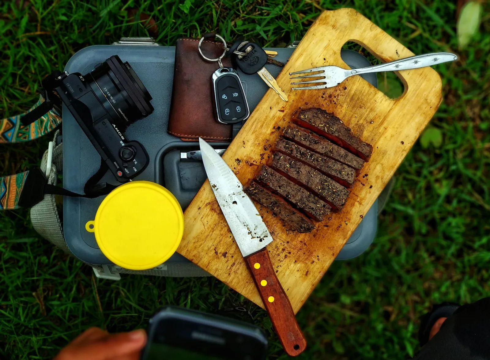 Sliced steak on a cutting board with a knife and fork